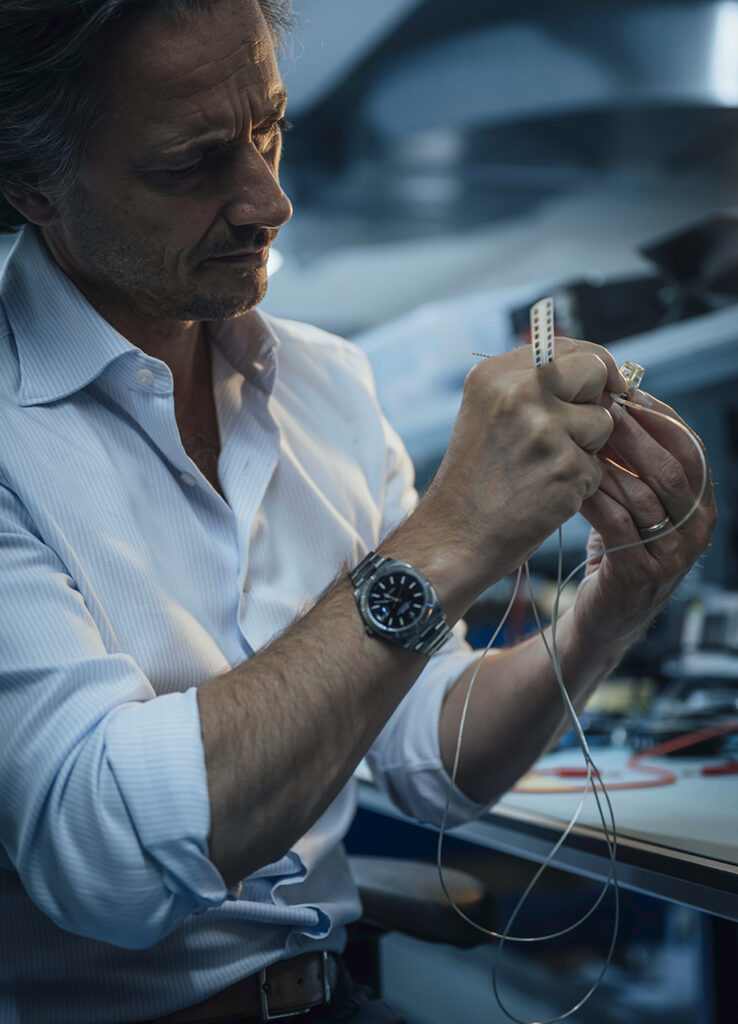 Grégoire Courtine, neurocientífico, sostiene el implante utilizado en sus pacientes. Courtine ha estado probando una nueva pieza de tecnología: campos de electrodos que son mucho más precisos a la hora de apuntar a todas las raíces nerviosas importantes para controlar los músculos de las piernas. “Realmente necesitamos la máxima precisión”, explica. Foto: ©Rolex/Gabriel Monnet.