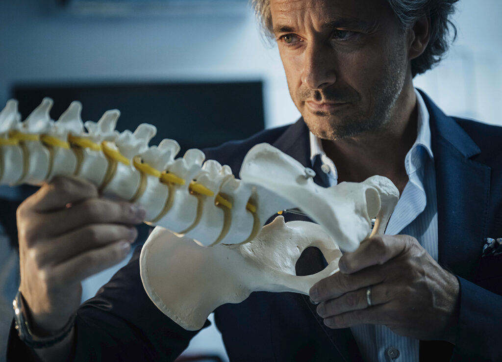 El neurocientífico Grégoire Courtine inspecciona un modelo anatómico de una columna vertebral en el laboratorio de investigación del Instituto Federal Suizo de Tecnología de Lausana. Como escalador apasionado, Courtine se ve profundamente afectado al ver a jóvenes deportistas quedar paralizados por lesiones deportivas. Ha dedicado su vida a tratar estas lesiones. Foto: ©Rolex/Gabriel Monnet.