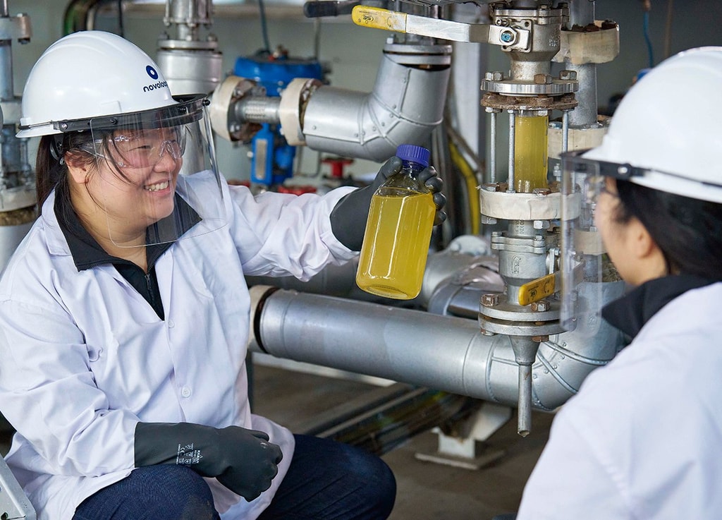 Las cofundadoras de Novoloop, Jeanny Yao (izq.) y Miranda Wang, usan cascos y viseras protectoras mientras inspeccionan una botella de monómeros. Foto: © Rolex / Greg White