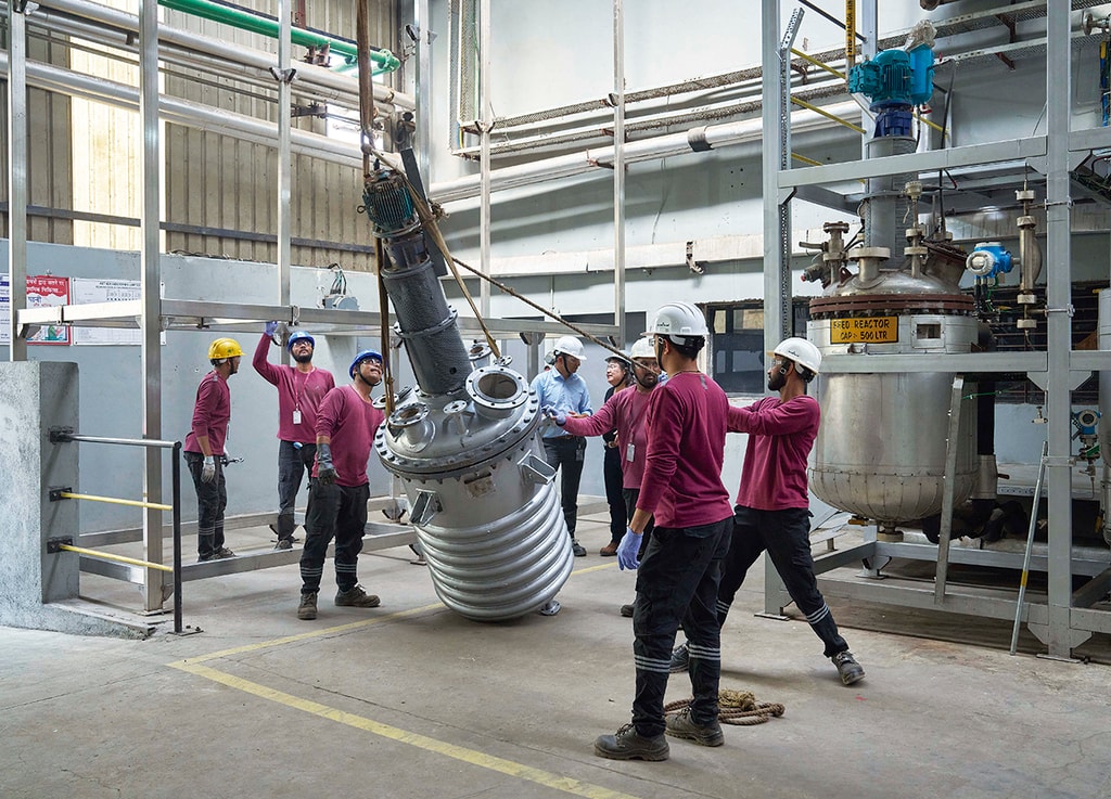 Miembros de Aether Industries, fabricante de productos químicos especializados y socio de Novoloop en un proyecto visionario de reciclaje de residuos plásticos, asisten a la instalación de un reactor en la planta piloto de demostración en Surat, India. Actualmente, sólo se recicla 9% de los cientos de millones de toneladas de plástico que se producen cada año. Foto: © Rolex / Greg White