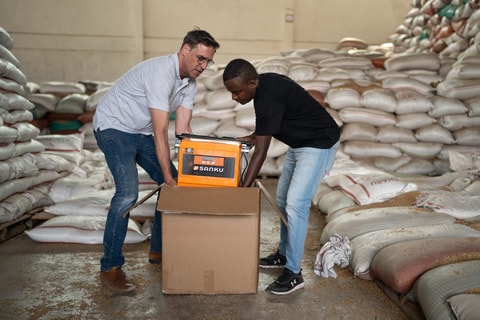 Felix Brooks-church, cofundador de Sanku, y Dawit Biruk Zegeye, gerente de desarrollo de negocios de Sanku, desempacan un dosificador en la fábrica Addis Flour Mill en Burayu, Etiopía. El dosificador entrega dosis precisas de micronutrientes esenciales para la harina durante el proceso de molienda. Foto: © Rolex / Aurélie Marrier d’Unienville.