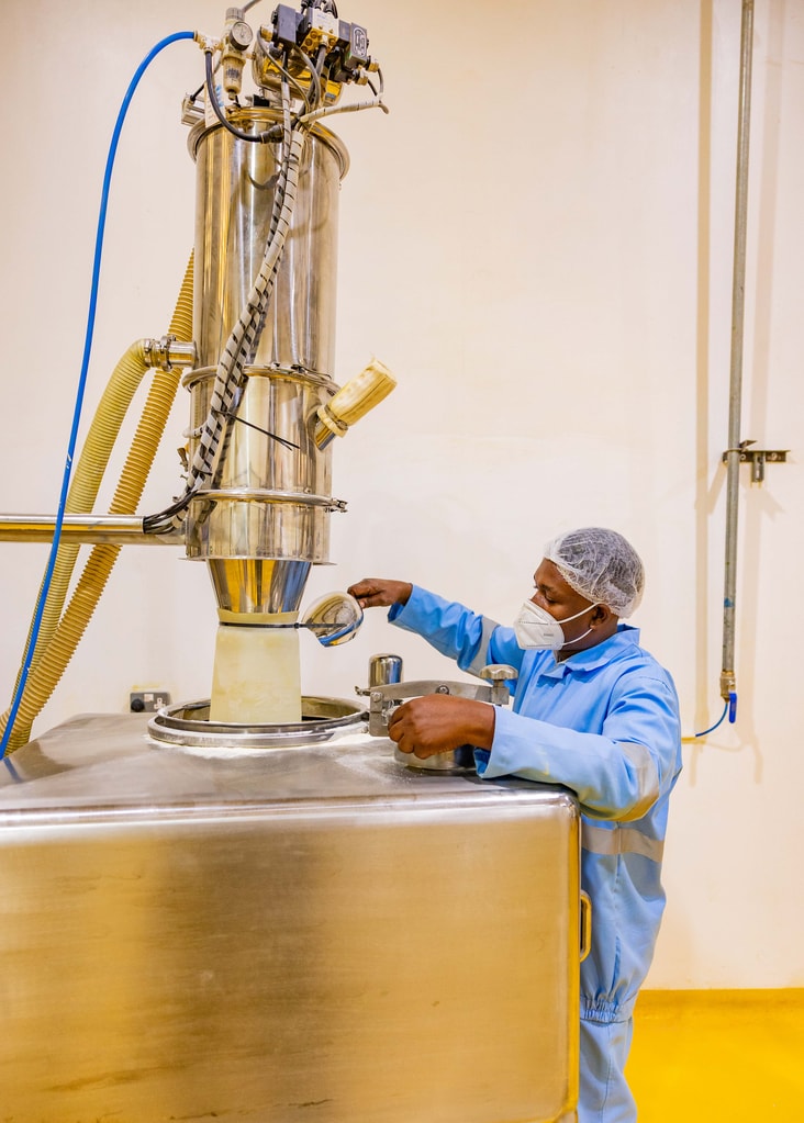Un trabajador supervisa la premezcla en la fábrica de mezclado de nutrientes en Dar es Salaam, Tanzania. La planta ya produce suficiente premezcla para enriquecer más de 5,000 millones de platos de comida cada año. Foto: ©Rolex / Peter Ndung’u.